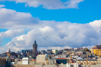 Buildings in city against cloudy sky