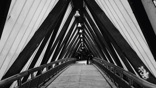 Low angle view of woman walking on footbridge