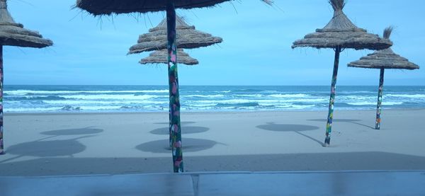 Lifeguard hut on beach against sky