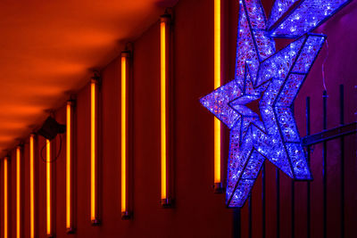 Low angle view of illuminated lighting equipment in building