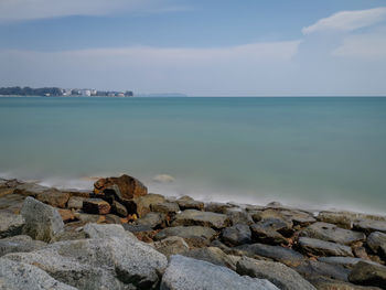 Scenic view of rocks on beach against sky