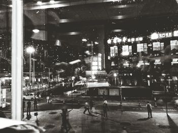 People walking in illuminated city at night