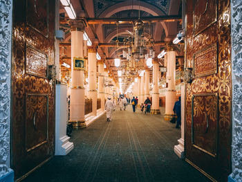 Rear view of people walking in illuminated building