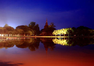 Reflection of trees in lake at sunset