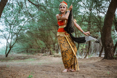 Portrait of young woman standing in forest