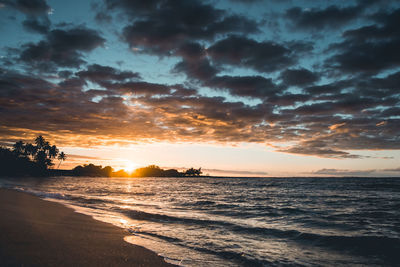 Scenic view of beach against sky during sunset