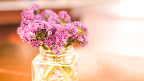 Wild violet flowers in glass bottle on rustic wooden table