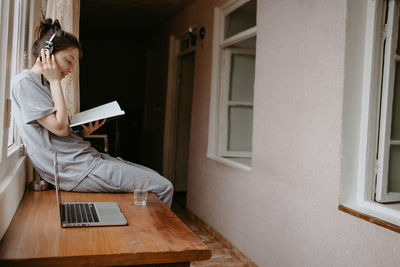 Portrait of young woman using digital tablet while sitting at home