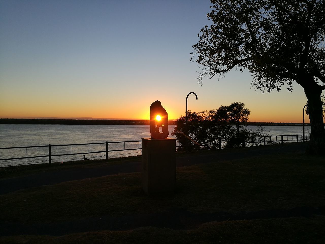 SILHOUETTE RAILING BY SEA AGAINST SKY AT SUNSET