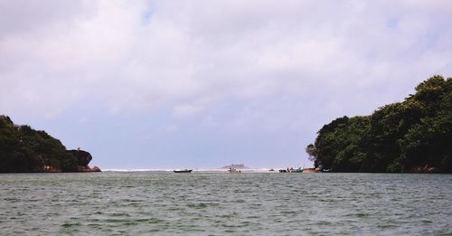 Boats sailing in sea against sky