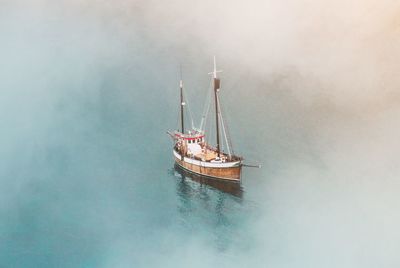 High angle view of sailboat sailing on sea in foggy weather