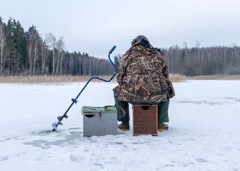 Landscape with ice fishing on a frozen lake, winter sport, outdoor recreation	