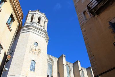 Low angle view of bell tower against clear blue sky