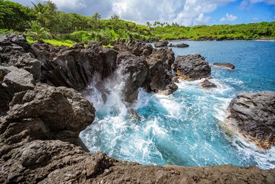 Scenic view of rocks in sea against sky