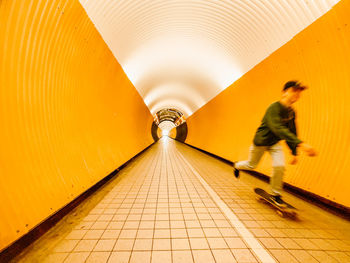 People walking in illuminated tunnel