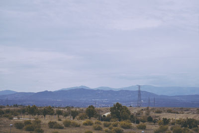 Scenic view of field and mountains against sky