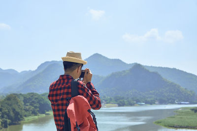 Man standing by mountain against sky