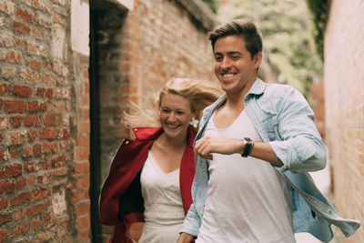 Young couple standing against wall