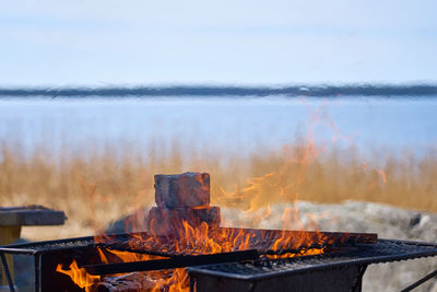 Fire in a rusty vintage grill outdoor on the beach of the sea.