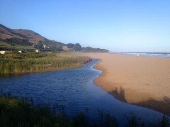 Scenic view of beach against blue sky