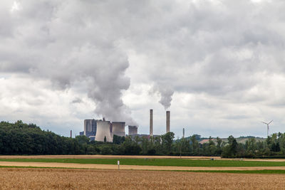 Factory against cloudy sky