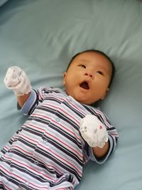 High angle view of cute baby lying on bed