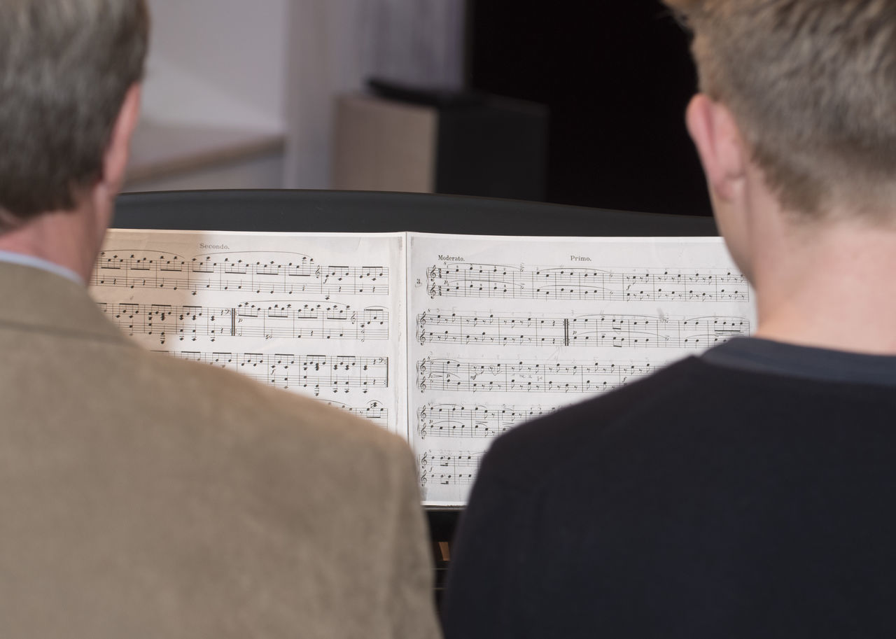 REAR VIEW OF MAN AND BOOK ON PAPER