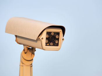 Close-up of security camera against clear sky