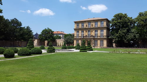 Lawn by building against sky