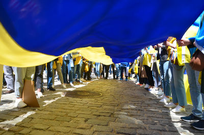 Demonstrators hold a giant ukrainian flag in new york city to stand in solidarity with ukraine.