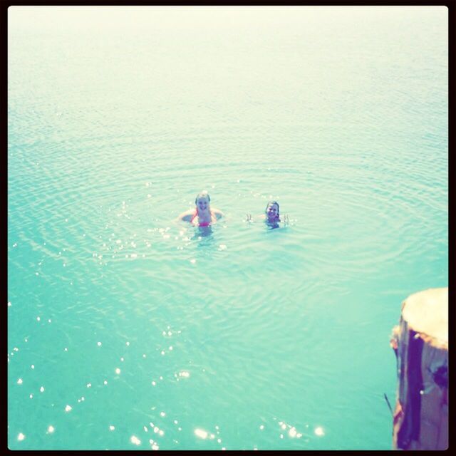 water, lifestyles, leisure activity, transfer print, waterfront, men, sea, auto post production filter, nautical vessel, high angle view, vacations, rippled, enjoyment, blue, swimming, person, boat