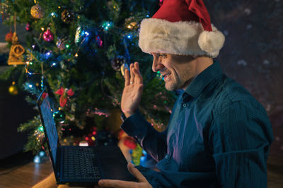 Side view of man using laptop while sitting on table