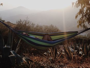 Man sleeping in hammock during sunset