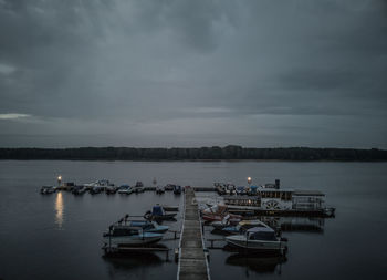 Boats moored in lake against sky