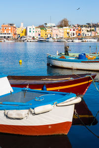 Boats moored in sea against buildings in city