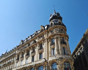 Low angle view of historical building against clear blue sky