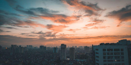 Modern buildings against sky during sunset