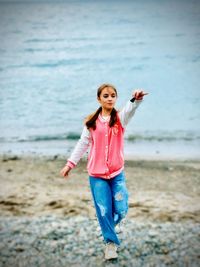 Full length of young woman standing at beach