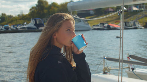 Girl drinking coffee at lake