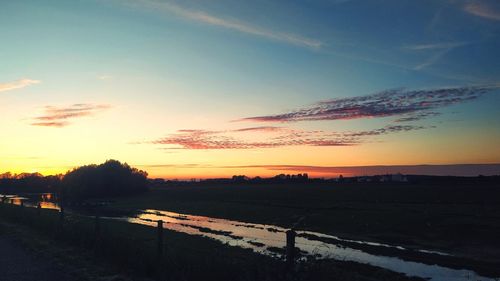 Scenic view of silhouette field against sky during sunset