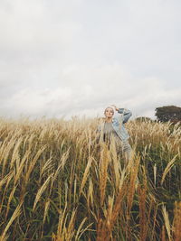 Woman standing in farm against sky