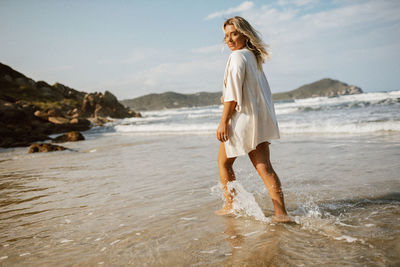 Portrait of young woman standing at beach