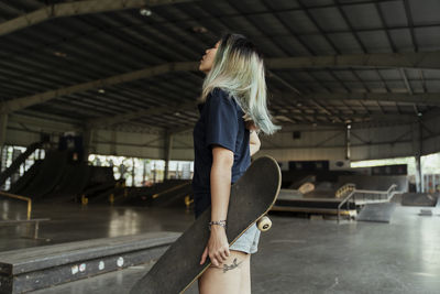 Side view of woman with skateboard