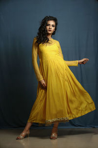 Woman in yellow dress standing indoors