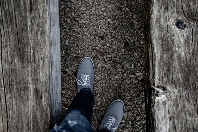 Low section of person standing on wood