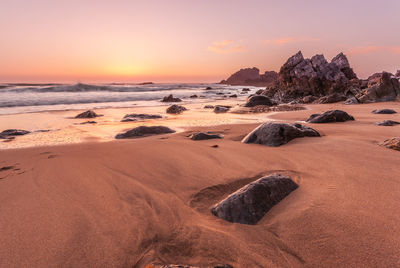 Scenic view of beach against sky during sunset