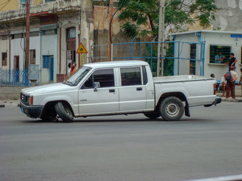 Vintage car on street against buildings in city