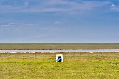 Lifeguard hut on field against sky