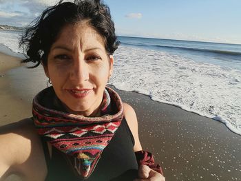 Portrait of smiling young woman sitting on beach