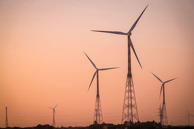 Silhouette of wind turbine against sky during sunset